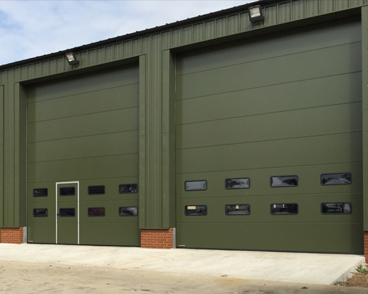 Sectional doors industrial with wicket door in green